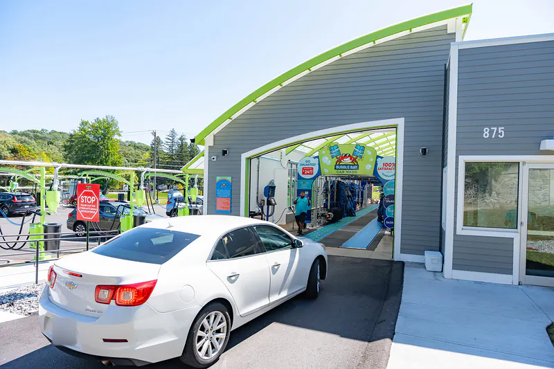 A white sedan pulling up to the tunnel entrance of the Haverhill wash at 875 South Main Street